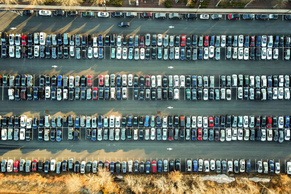Bilde av en parkeringsplass ovenfra med masse biler